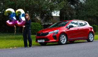 Auto Express pictures editor Dawn Grant standing next to the Renault Clio E-Tech while holding &#039;33&#039; number balloons